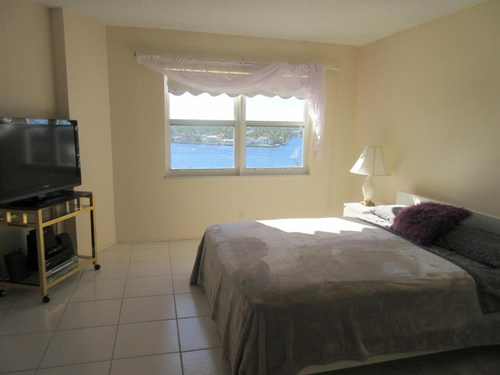 1200 Hibiscus Avenue, Unit 801 Pompano Beach, FL 33062 - Photo 8 of 12 a bedroom with a bed and a flat screen tv