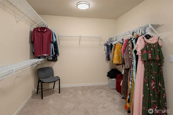 a view of walk in closet with clothes and shoes