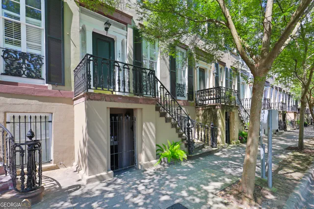 a view of a house with a tree beside a yard