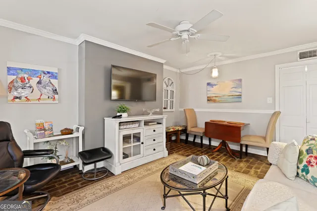 a living room with furniture a flat screen tv and kitchen view