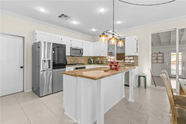 a large kitchen with granite countertop a sink and cabinets