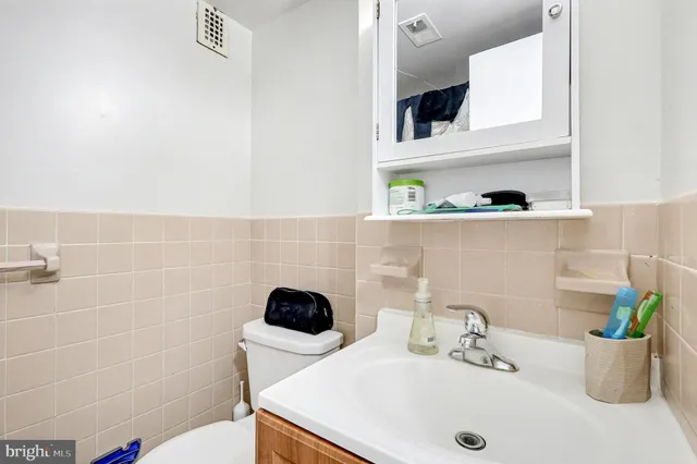 a bathroom with a sink a toilet and mirror