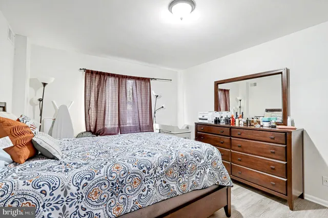 a bedroom with a bed and a mirror on dresser