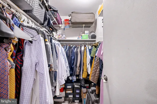 a view of walk in closet with clothes and shoes