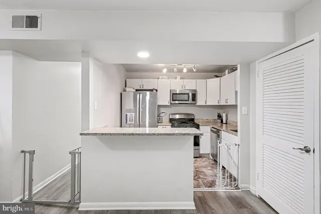 a kitchen with stainless steel appliances a sink and cabinets