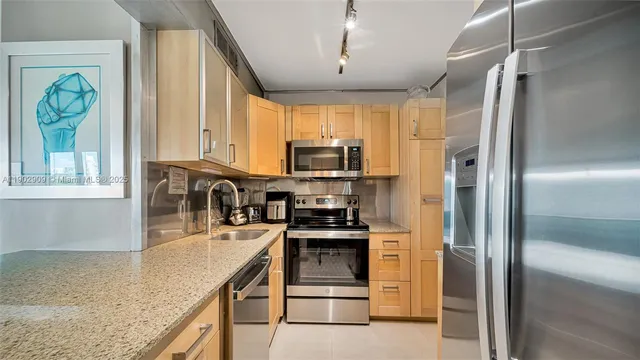 a kitchen with stainless steel appliances granite countertop a refrigerator and a sink