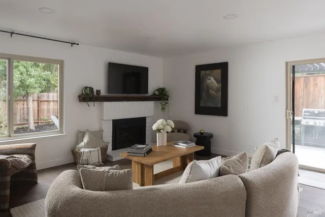 a living room with furniture mirror on the wall and a fireplace
