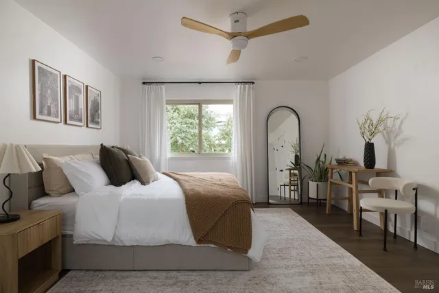 a bedroom with a bed a mirror and a window