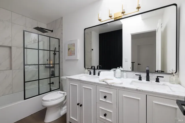 a bathroom with a toilet a sink and mirror
