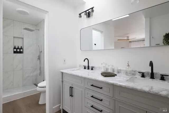 a bathroom with a sink a toilet and shower