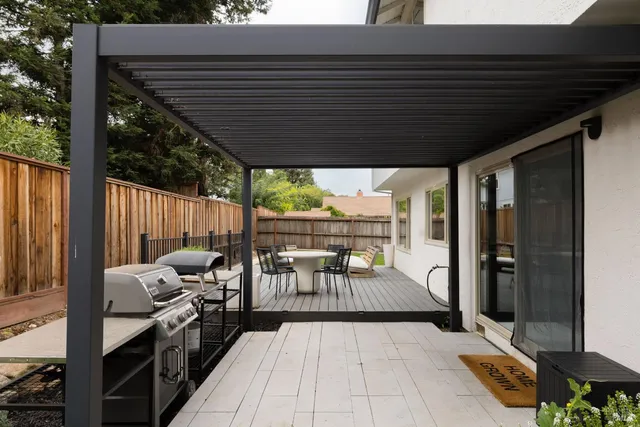 a view of a patio with table and chairs potted plants with wooden floor and fence