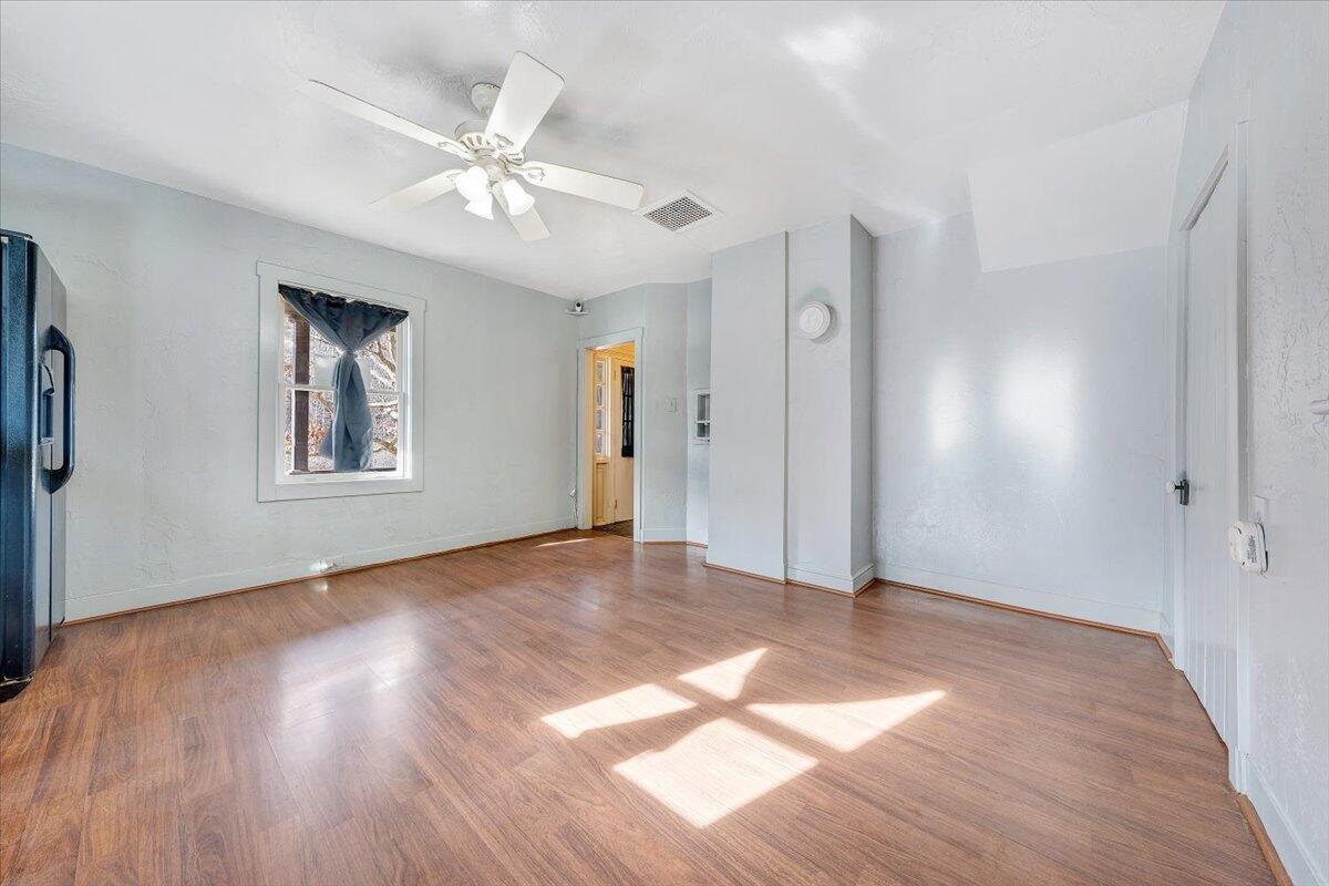 6702 Ferrum Mountain Road Callaway, VA 24067 - Photo 13 of 45 a view of an empty room with wooden floor and a ceiling fan