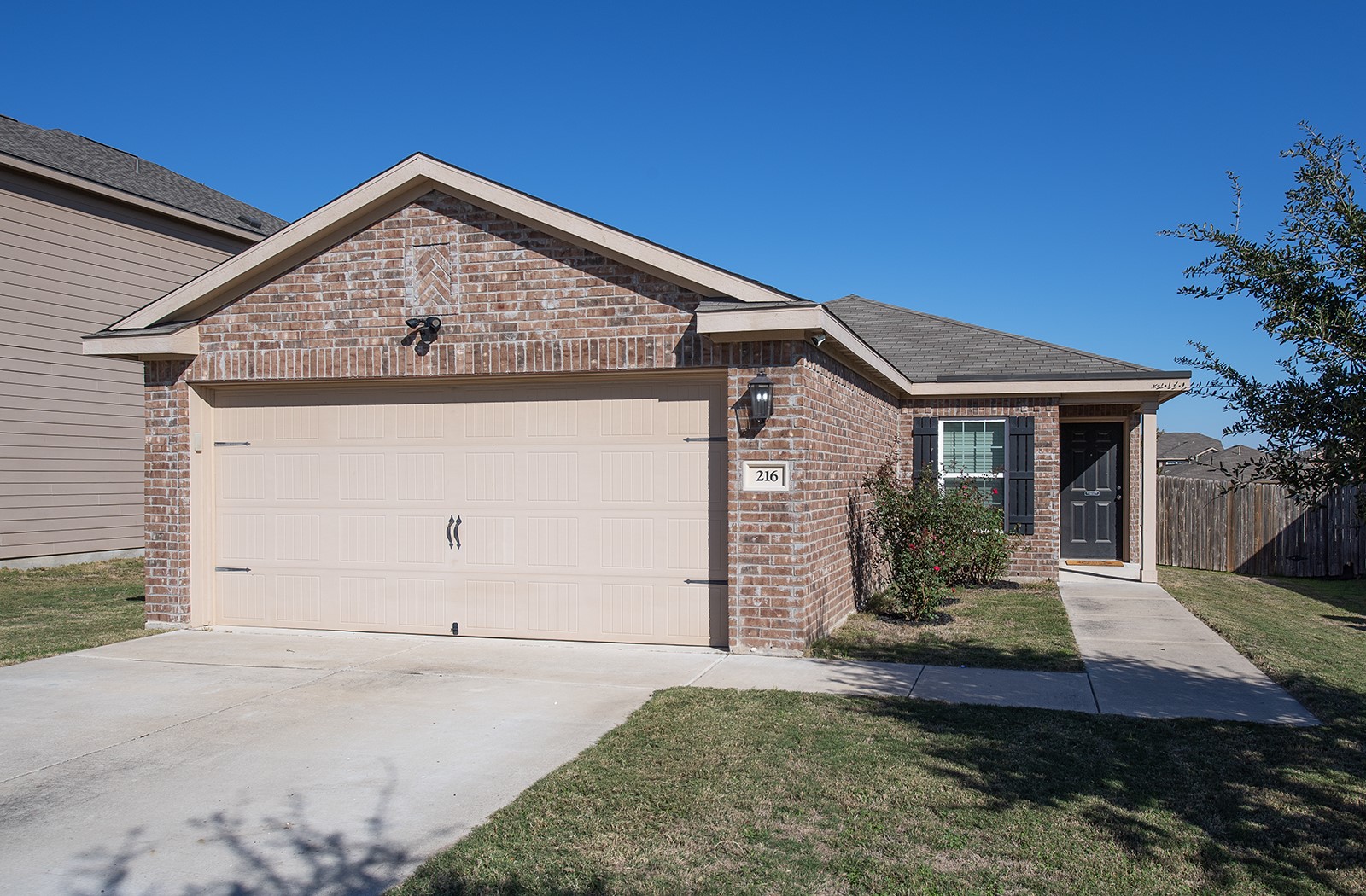 216 Millers Loop Jarrell, TX 76537 - Photo 1 of 31 View of front of property with brick siding, driveway, and a garage