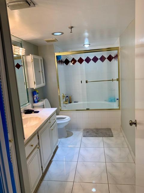 6400 Northwest 2nd Avenue, Unit 417 Boca Raton, FL 33487 - Photo 17 of 66 a bathroom with a granite countertop sink a mirror and a bathtub