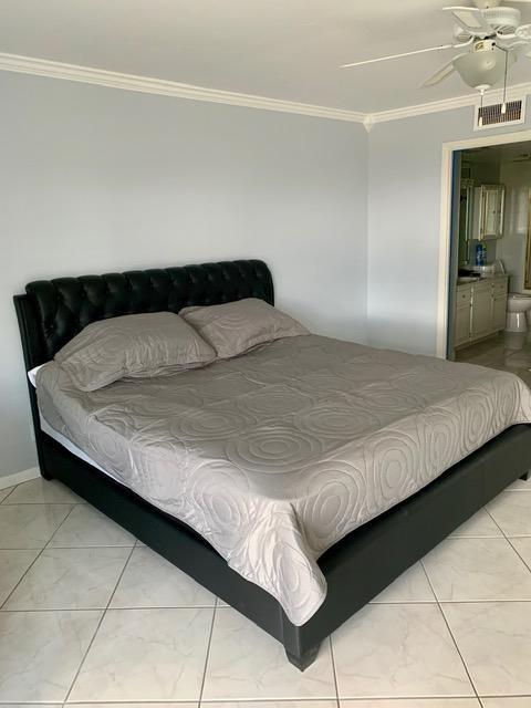 6400 Northwest 2nd Avenue, Unit 417 Boca Raton, FL 33487 - Photo 19 of 66 a bedroom with a bed and lamp with the dresser