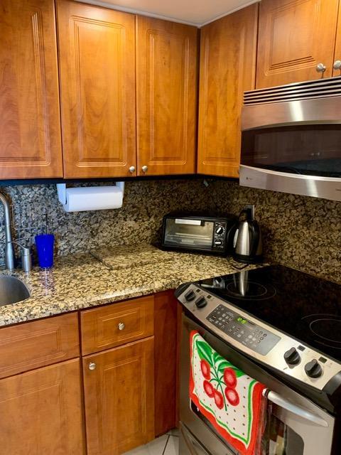 6400 Northwest 2nd Avenue, Unit 417 Boca Raton, FL 33487 - Photo 47 of 66 a kitchen with stainless steel appliances granite countertop a sink a stove and a microwave