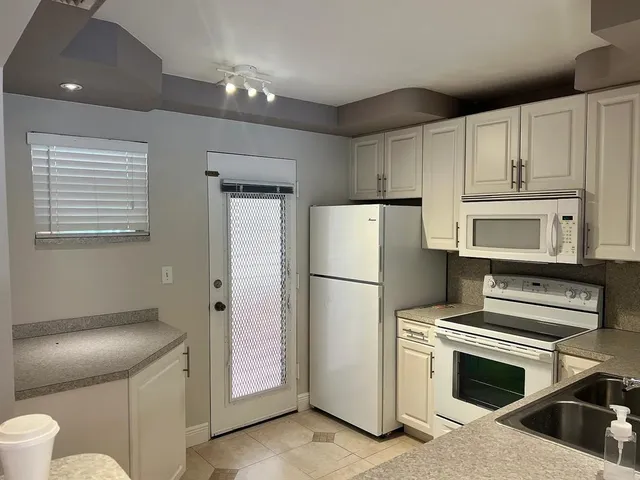 a kitchen with a refrigerator sink and stove