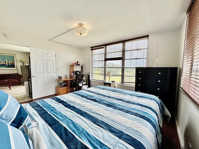a bedroom with a bed and a large window
