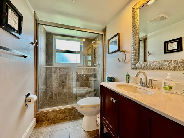 a bathroom with a sink a toilet and shower