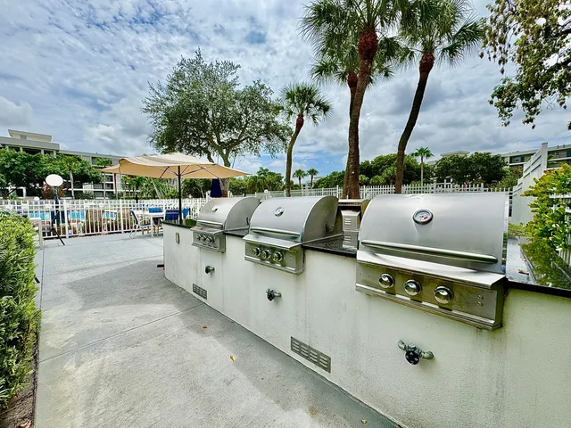 a view of a patio with table and chairs potted plants and a large tree