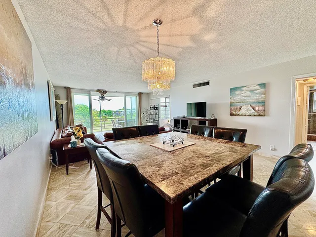 a living room with dining table and a chandelier
