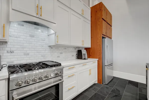 a kitchen with a stove and white cabinets