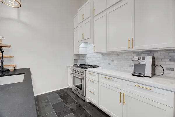 a kitchen with white cabinets and appliances
