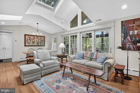 a dining room with wooden floor a chandelier a wooden table and chairs