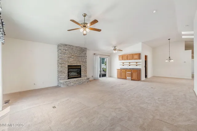 a view of an empty room with a fireplace and a window