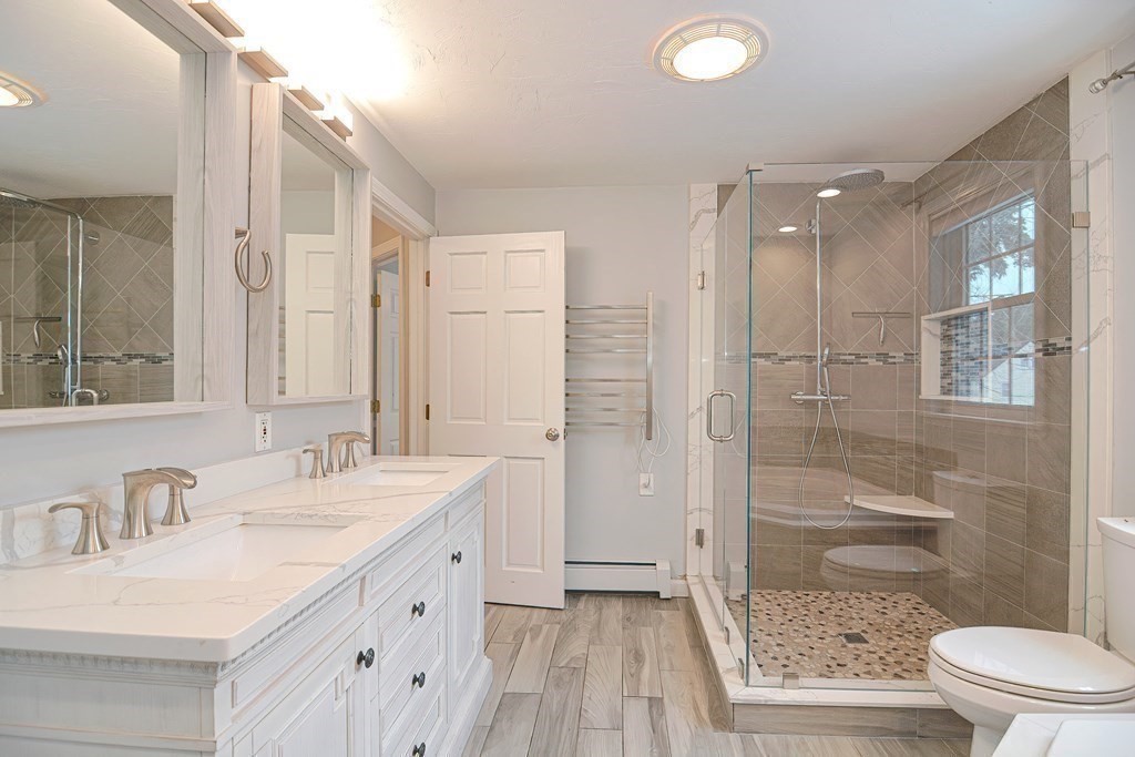 93 Cameron Road Norwood, MA 02062 - Photo 22 of 42 a bathroom with a granite countertop sink a mirror a toilet and shower