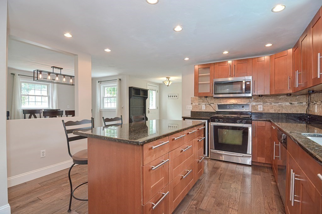 93 Cameron Road Norwood, MA 02062 - Photo 5 of 42 a kitchen with stainless steel appliances kitchen island granite countertop a stove top oven a sink a refrigerator and cabinets