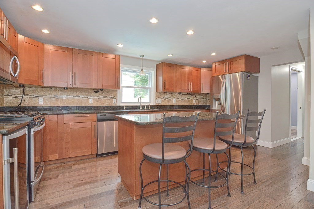 93 Cameron Road Norwood, MA 02062 - Photo 7 of 42 a kitchen with stainless steel appliances granite countertop a stove a sink refrigerator and a microwave