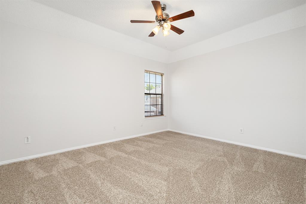 906 Beau Drive Coppell, TX 75019 - Photo 22 of 35 an empty room with a window and a fan