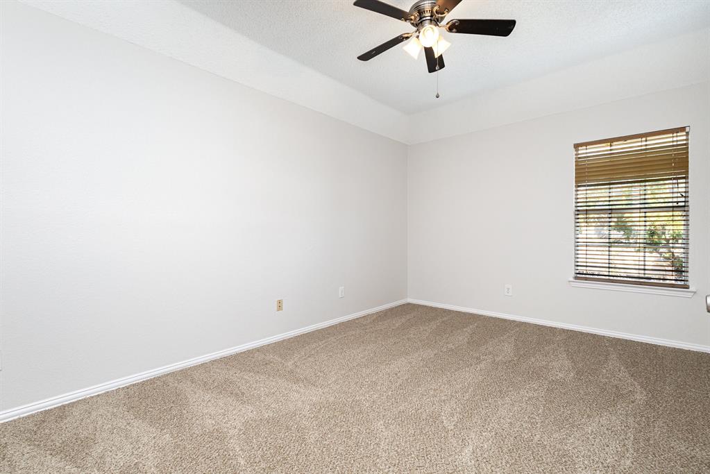 906 Beau Drive Coppell, TX 75019 - Photo 23 of 35 an empty room with a window and a fan