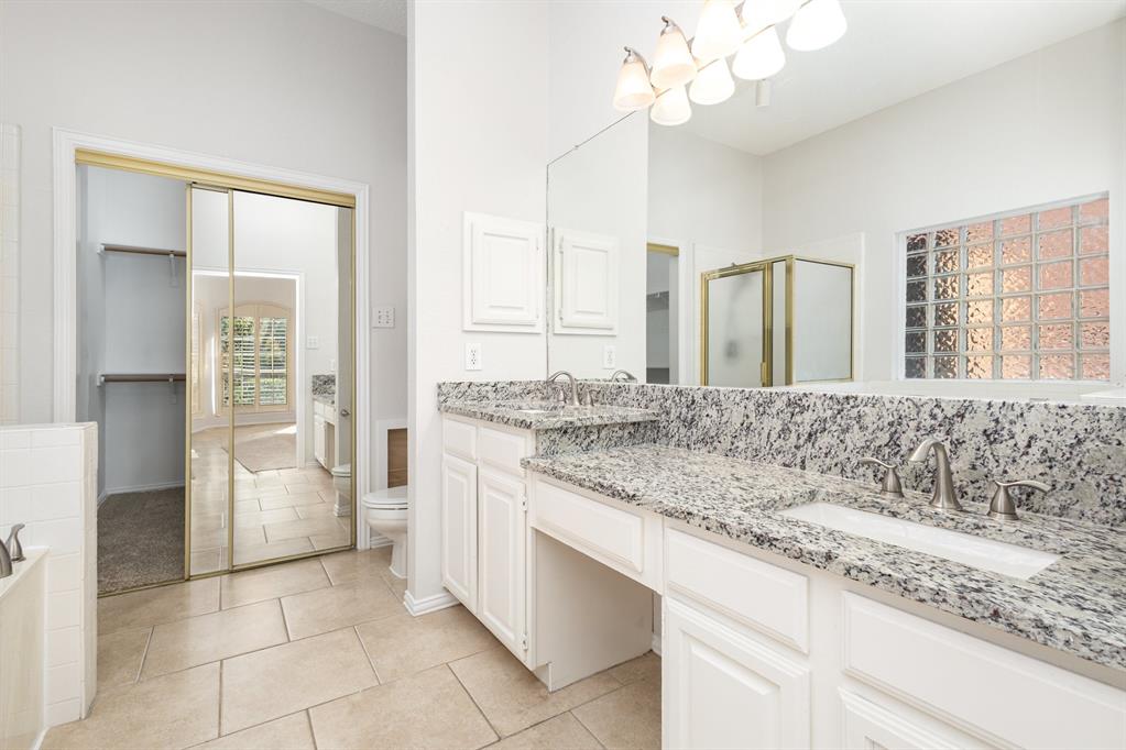 906 Beau Drive Coppell, TX 75019 - Photo 26 of 35 a bathroom with a granite countertop sink a large mirror and a shower