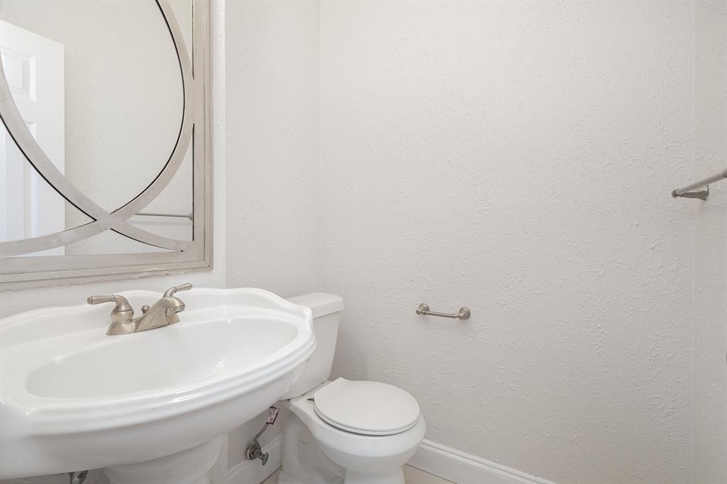 906 Beau Drive Coppell, TX 75019 - Photo 27 of 35 a white toilet sitting next to a bathroom sink