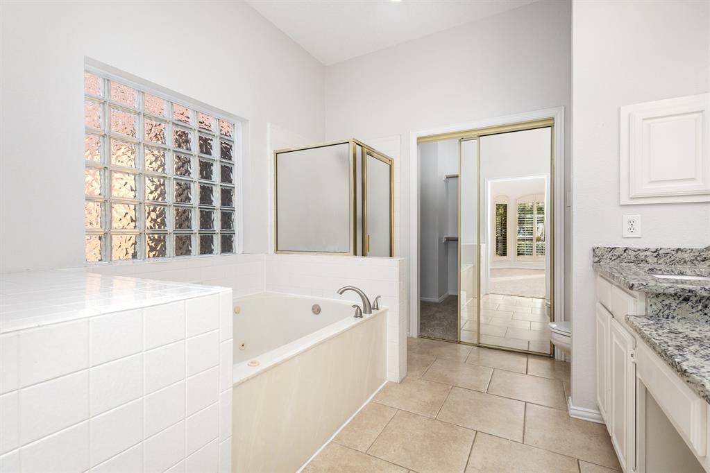 906 Beau Drive Coppell, TX 75019 - Photo 28 of 35 a bathroom with a granite countertop sink a mirror and a bathtub