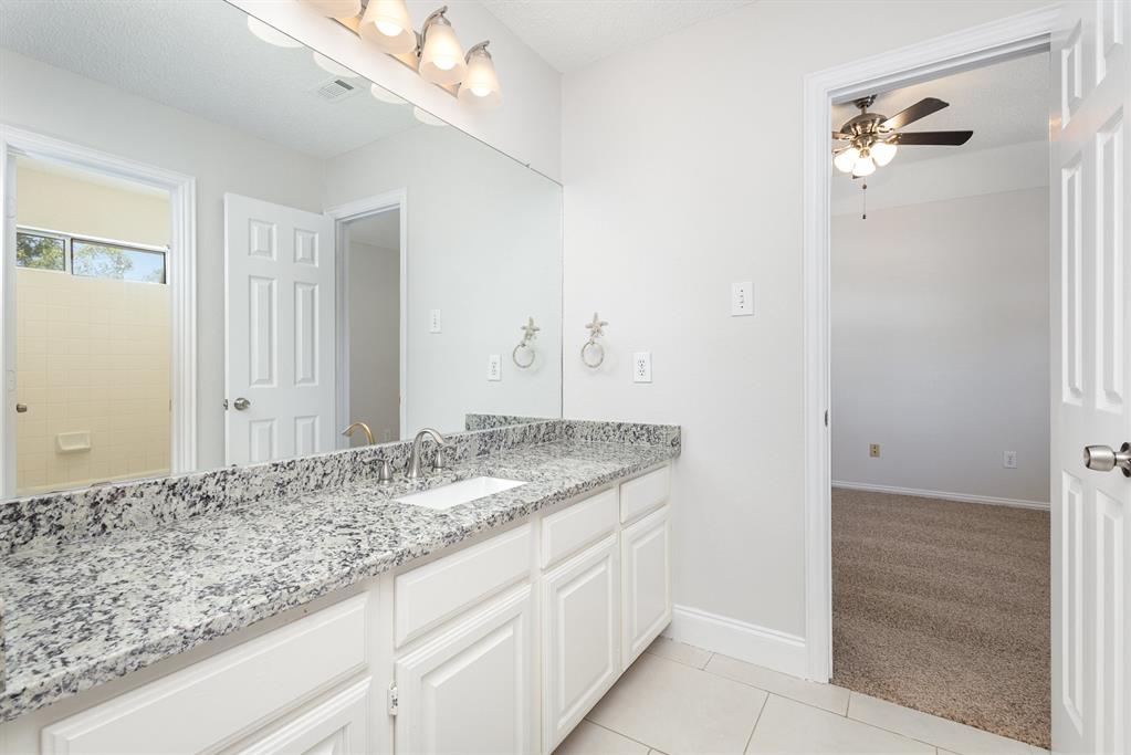 906 Beau Drive Coppell, TX 75019 - Photo 29 of 35 a bathroom with a granite countertop sink and a mirror