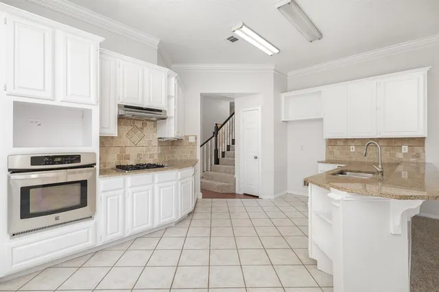 a kitchen with granite countertop a sink and a stove