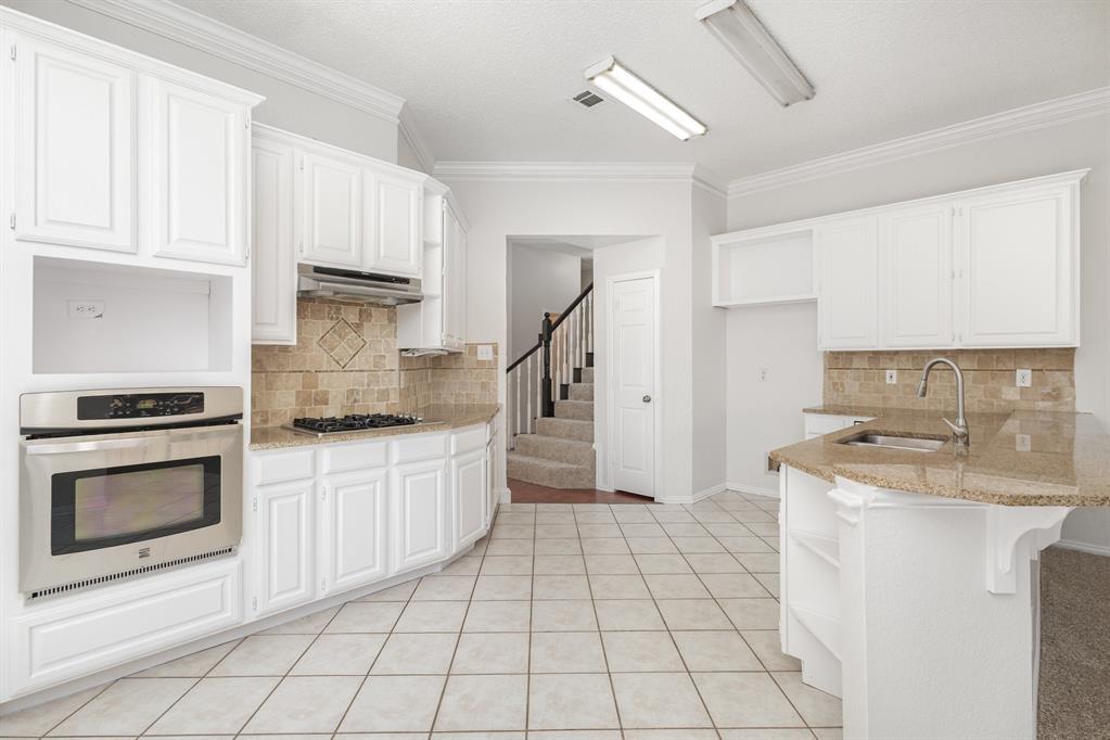 906 Beau Drive Coppell, TX 75019 - Photo 6 of 35 a kitchen with a stove a sink and a refrigerator