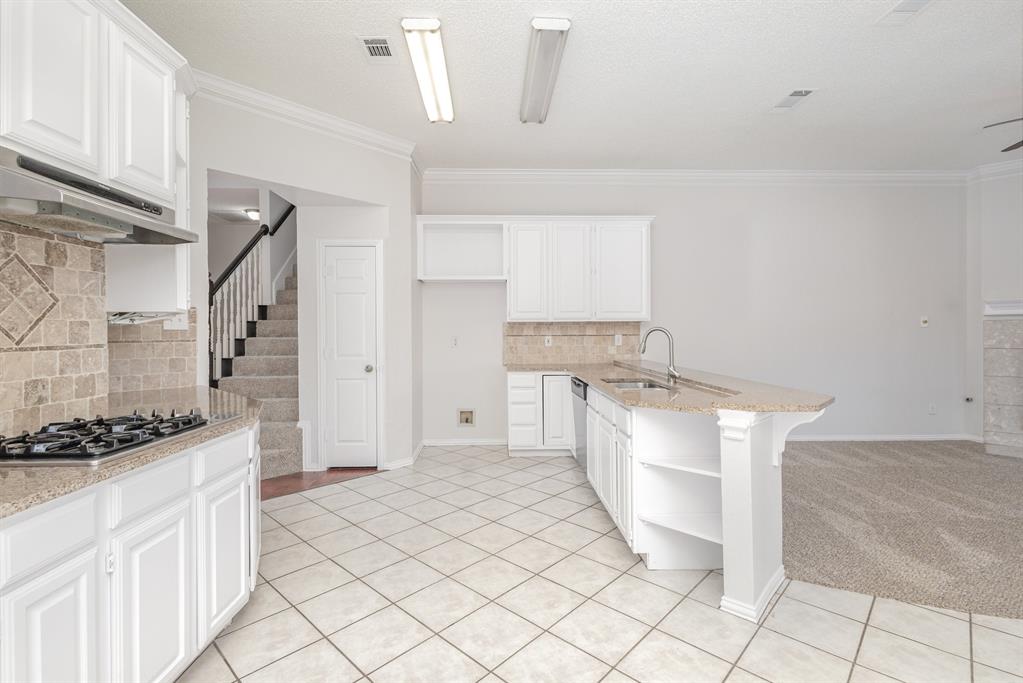 906 Beau Drive Coppell, TX 75019 - Photo 7 of 35 a kitchen with granite countertop a sink and a stove
