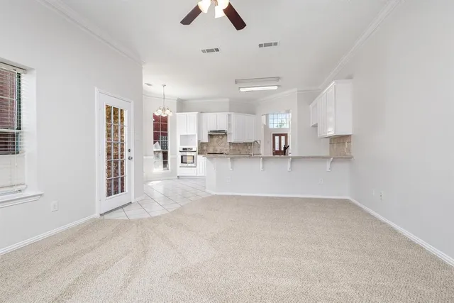 an empty room with windows and fireplace