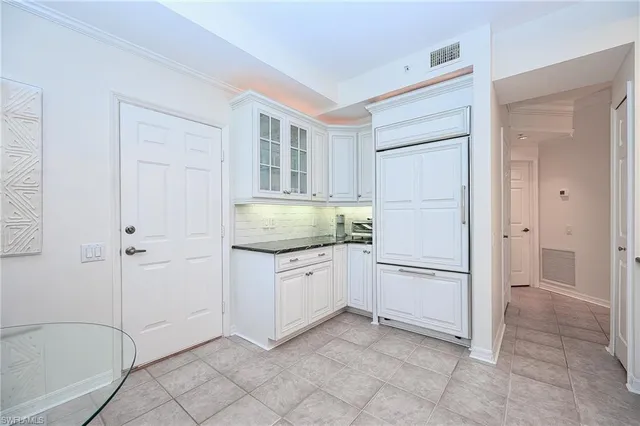 a kitchen with white cabinets and white appliances