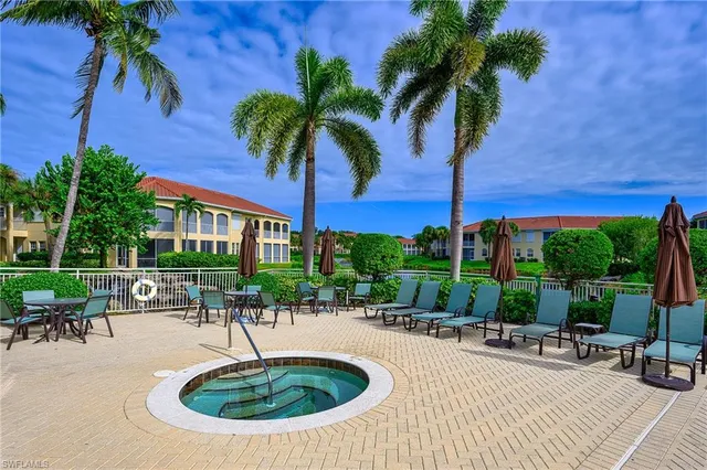a swimming pool with outdoor seating yard and palm tree