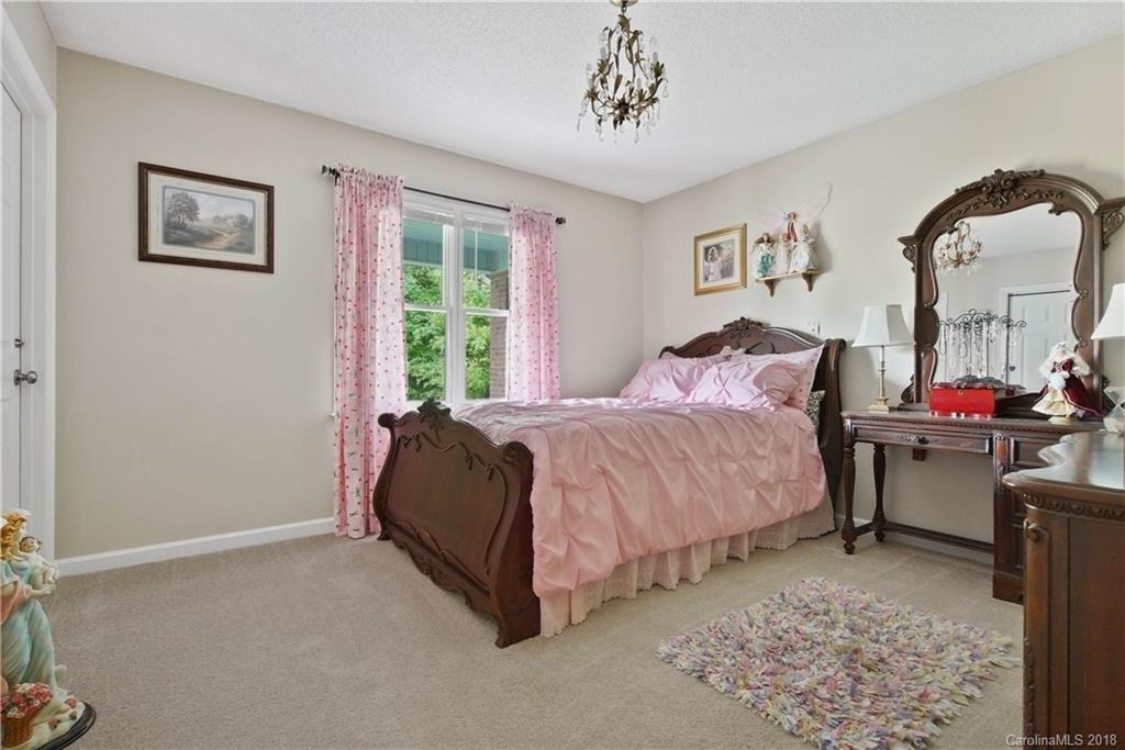 1948 Kadena Lane York, SC 29745 - Photo 17 of 25 a spacious bedroom with a bed a table and painting on the wall