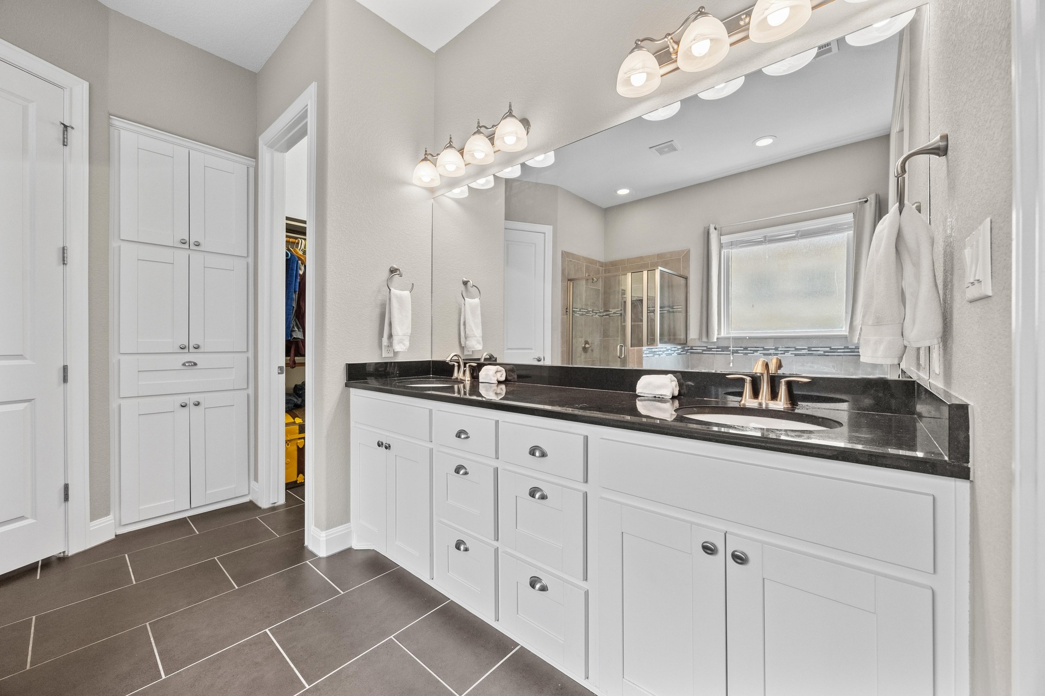 2114 Manada Trail Cedar Park, TX 78641 - Photo 12 of 36 a bathroom with a granite countertop double vanity sink a mirror and a bathtub