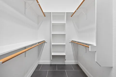 a view of walk in closet with empty racks