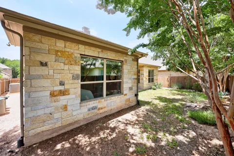 a view of a house with a large window and wooden fence