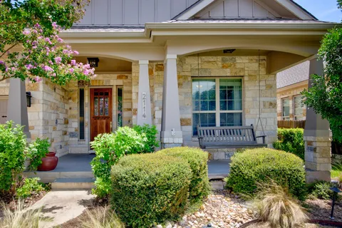 a view of a house with potted plants and a table and chairs