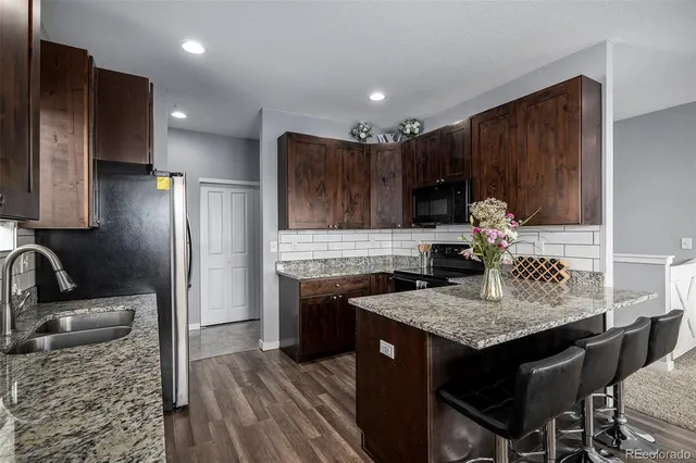 a kitchen with kitchen island granite countertop a sink appliances and cabinets